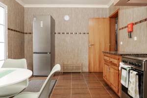 a kitchen with a refrigerator and a table and chairs at Casa da Bela Vida in Calhetas