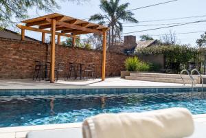 a patio with a table and chairs next to a swimming pool at MAE Singular Hotel in Córdoba