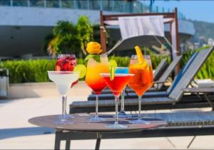 four drinks on a tray on a table near a pool at Hotel Nacional Rio de Janeiro in Rio de Janeiro
