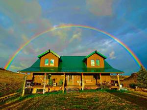 a rainbow over a house with a green roof at The Shepherd’s Nook in Livingston