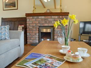 a living room with a table and a fireplace at Ty Nant in Llanon