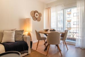 Una sala de estar con una mesa y una mesa y sillas. en Sea la Vie by LovelyStay, en Matosinhos