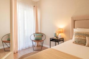 Un dormitorio con una cama y dos sillas y una ventana. en Sea la Vie by LovelyStay, en Matosinhos