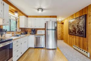 a kitchen with white cabinets and a stainless steel refrigerator at Ski Haus Retreat - Unit B in Dover