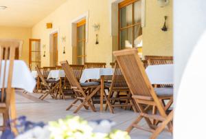 a row of wooden chairs and tables in a restaurant at Regia Panzió in Halászi