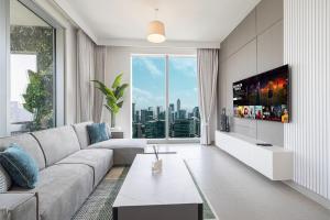 ドバイにあるStunning Downtown 4BR Sky High Luxury Apartment with Fountain Viewsのソファと大きな窓のあるリビングルーム