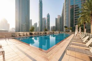 ドバイにあるStunning Downtown 4BR Sky High Luxury Apartment with Fountain Viewsの高層ビルが立ち並ぶ街の真ん中にあるプール