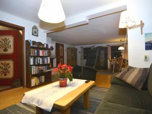 a living room with a couch and a table with flowers on it at Ferienhaus in Bayern mit Waldblick in Weigelsberg