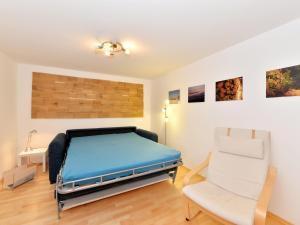 a bedroom with a bed and a chair in it at Ferienhaus in Bayern mit Waldblick in Weigelsberg