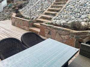 un tavolo e delle sedie su un ponte con delle rocce di 8 person holiday home in Urangsvåg-By Traum a Ervik