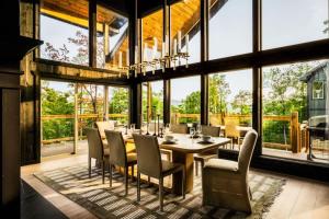 a dining room with a table and chairs and large windows at Midnight Mountain in Sevierville