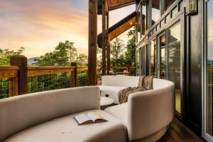 a living room with couches and a book on a balcony at Midnight Mountain in Sevierville +64 photos
