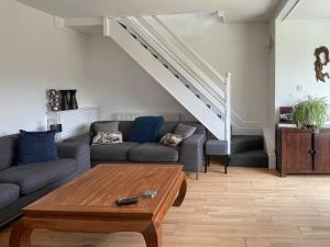 a living room with a couch and a staircase at The Cottage At Stanley Villa in Southport