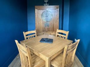 a wooden table with chairs and a book on it at The Cottage At Stanley Villa in Southport