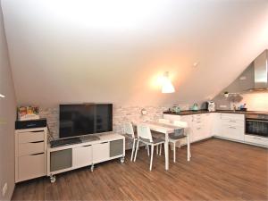 eine Küche mit Tisch, Stühlen und Fernseher in der Unterkunft Ferienhaus in Obernburg am Edersee in Vöhl