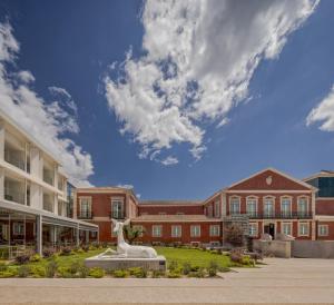 ein Campus mit einer Statue vor einem Gebäude in der Unterkunft MACAM Hotel in Lissabon