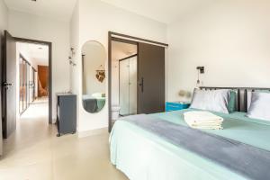 a bedroom with a large bed and a bathroom at Casa com piscina, vista das montanhas, terraço, quintal in Pirenópolis