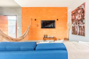a bedroom with a blue bed and a tv on a wall at Casa com piscina, vista das montanhas, terraço, quintal in Pirenópolis