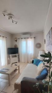 a living room with a couch and a table at Agia Marina House, walking distance to the beach in Aghia Marina