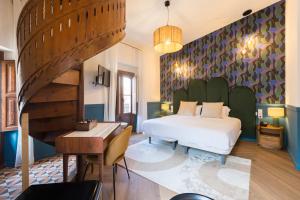 a bedroom with a bed and a desk and a piano at Hotel La Marsellesa in Pego
