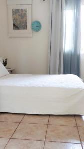a bed in a bedroom with a clock on the wall at Agia Marina House, walking distance to the beach in Aghia Marina
