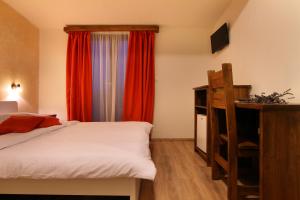 Un dormitorio con una cama y una ventana con cortinas rojas. en Bed & Breakfast Tonivale, en Skrbčići