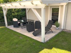 a patio with a table and chairs under a pergola at Forest-Fringed Comfort in Friedrichshöhe