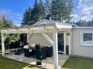 a white pergola with a table on a patio at Forest-Fringed Comfort in Friedrichshöhe