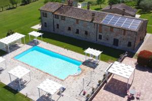 an overhead view of a swimming pool with a house with a solar roof at Agriturismo Case Corboli villetta Rufino in Todi