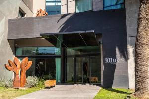 a building with a glass entrance with a tree at MAE Singular Hotel in Cordoba