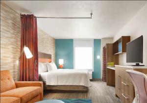 a hotel room with a bed and a tv at Home2 Suites By Hilton New Braunfels in New Braunfels