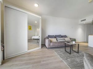 a living room with a couch and a large mirror at The Sharon Ocean Pearl in Herzliya B