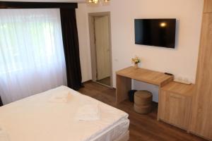 a bedroom with a bed and a television on the wall at La Brazi by BMD in Vulcan