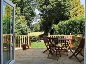 a patio with a table and chairs on a deck at Bramble Cottage in Wimborne Minster +2 photos