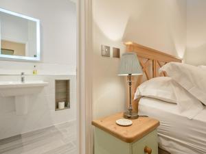 a bedroom with a bed and a lamp on a night stand at The Bunker in Sennen