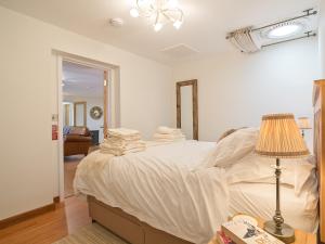 a bedroom with a large white bed with a lamp at The Bunker in Sennen