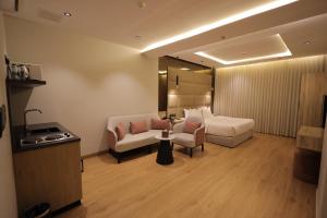 a hotel room with a bed and a couch and a table at XYZ Hotel Al Yasmin in Riyadh