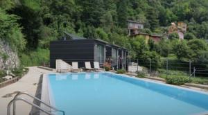 a large swimming pool in front of a house at Lake Como Ti Amo - Rooftop Pool to share in Nesso +26 photos