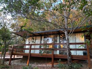 a house in the woods with a wooden fence at Piribless Chalés - Diamond in Pirenópolis