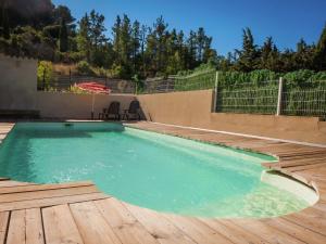 a swimming pool with a wooden floor and a wooden deck at Sunny Escape to Serenity in Fraissé-des-Corbières
