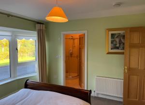 a bedroom with a bed and a door to a bathroom at Hybrasil in Westport
