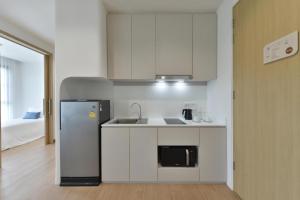 a white kitchen with a refrigerator and a sink at SENS Hotel Bangkok - Kubon in Bangkok +58 photos