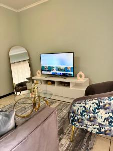 ヨハネスブルグにあるCosy apartmentのリビングルーム(棚に薄型テレビ付)