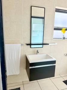 ヨハネスブルグにあるCosy apartmentの洗面台と鏡のあるバスルーム