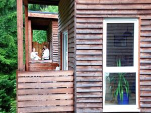 two people standing on the porch of a wooden house at Holiday Home with Garden in Altenfeld