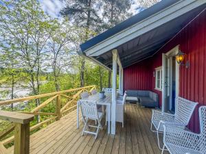 a wooden deck with a table and chairs on a red house at Holiday Home Punatulkku by Interhome in Hirsjärvi