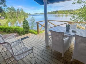 a deck with chairs and a table with a view of a lake at Holiday Home Punatulkku by Interhome in Hirsjärvi