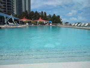 a large pool of blue water with buildings in the background at Estudios con y sin balcón en Sunny Isles Beach in Sunny Isles Beach