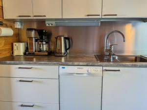 a kitchen with white cabinets and a sink at Holiday Home Lähikaltio 314 by Interhome in Äkäslompolo