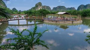 a bridge over a river with mountains in the background at Chinh Thu Garden Retreat in Ninh Binh +53 photos